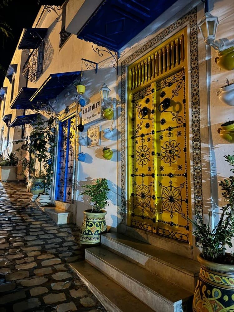Porte dorée éclairée la nuit, lanternes et pavés de la ruelle
